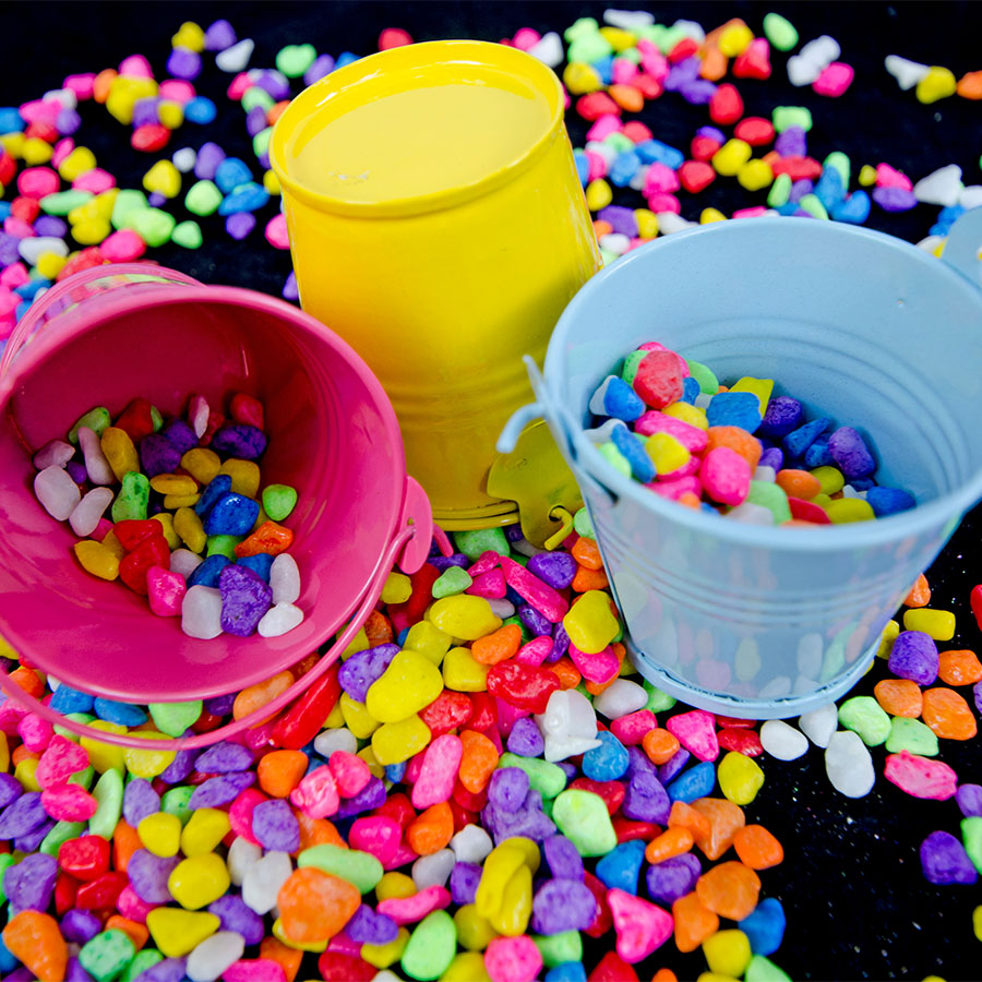 Colorful candy scattered with buckets and cups, vibrant and playful.