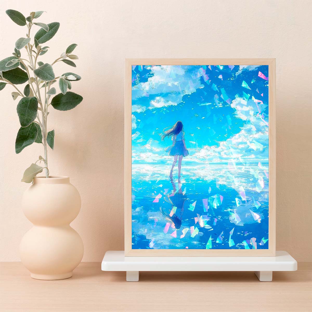 Framed artwork of a girl in a blue dress standing on water with a blue sky and clouds in a minimalistic room.