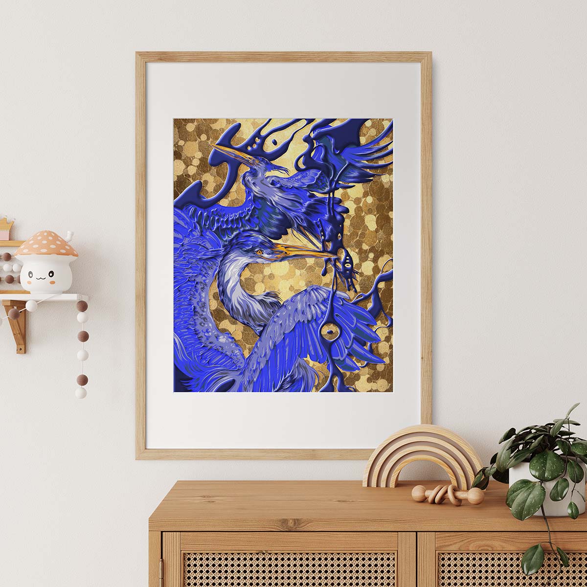 Framed artwork of a blue crane on a gold background, displayed in a room with a wooden cabinet and decorative items.