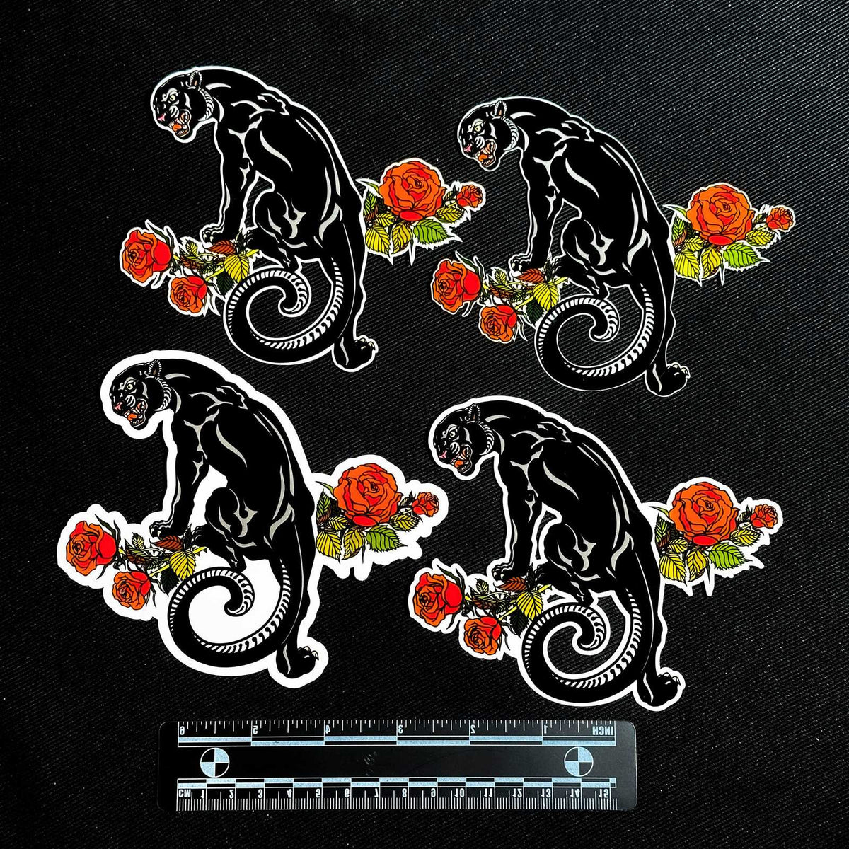Four black panther designs with red roses on a black background, accompanied by a ruler for scale.